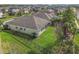 Aerial view of a fenced backyard featuring a well-maintained lawn, mature trees, and a screened patio at 6326 Waves End Pl, Apollo Beach, FL 33572