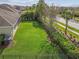 Spacious fenced backyard featuring a well-maintained lawn, mature landscaping, and shade trees at 6326 Waves End Pl, Apollo Beach, FL 33572
