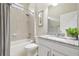 Bright bathroom featuring a shower-over-tub and granite-topped vanity at 6326 Waves End Pl, Apollo Beach, FL 33572