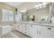 Bathroom with white cabinetry, granite countertops, a tub, a shower, and a large mirror at 6326 Waves End Pl, Apollo Beach, FL 33572