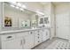 Bathroom showcasing a large mirror, granite countertops, and white cabinetry for ample storage at 6326 Waves End Pl, Apollo Beach, FL 33572