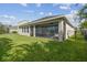 Backyard featuring a covered, screened lanai and lush, green lawn at 6326 Waves End Pl, Apollo Beach, FL 33572