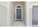 Close-up of a stylish front door with sidelights and a welcome mat, offering a warm and inviting entrance at 6326 Waves End Pl, Apollo Beach, FL 33572