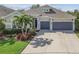 Beautiful home with a manicured lawn, landscaped garden, and a spacious driveway leading to a two-car garage at 6326 Waves End Pl, Apollo Beach, FL 33572