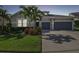 Charming single-story home with a well-manicured lawn, lush landscaping, and a spacious two-car garage at 6326 Waves End Pl, Apollo Beach, FL 33572