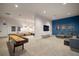 Open-concept game room features a shuffleboard table, TV, and comfortable seating in an entertainment space at 6326 Waves End Pl, Apollo Beach, FL 33572