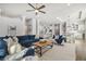 Inviting living room with a large blue sofa, modern ceiling fan, and open floor plan at 6326 Waves End Pl, Apollo Beach, FL 33572