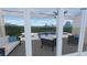 View through glass doors to the outdoor patio with luxurious seating and custom pool at 6326 Waves End Pl, Apollo Beach, FL 33572