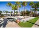 Playground with palm trees and two pink beach chairs in a beach sand setting at 6326 Waves End Pl, Apollo Beach, FL 33572