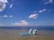 Beach chairs submerged in shallow water offer a unique seaside experience at 6533 Channelside Dr, New Port Richey, FL 34652