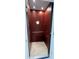 Private residential elevator featuring wood panels and a porthole window at 6533 Channelside Dr, New Port Richey, FL 34652
