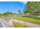 Community entrance featuring lush landscaping, mature trees, and brick signage under a clear blue sky at 6920 Lafayette N # 6920, Pinellas Park, FL 33781