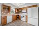 Open kitchen features oak cabinets, white appliances, and ample storage with tile floors at 6920 Lafayette N # 6920, Pinellas Park, FL 33781