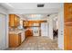Kitchen features oak cabinets, white appliances, and tile floors with an adjacent dining area at 6920 Lafayette N # 6920, Pinellas Park, FL 33781