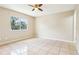 Bright bedroom featuring neutral walls, ceramic tile floors, and a ceiling fan at 7303 E Bank Dr, Tampa, FL 33617