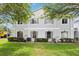 Two story townhouse with gray exterior paint, green grass, minimal landscaping and gray shuttered windows at 7303 E Bank Dr, Tampa, FL 33617