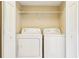 Laundry room with white washer, dryer, and wire shelving at 7303 E Bank Dr, Tampa, FL 33617