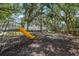 Community playground featuring a slide, swings, climbing dome, benches, mature trees and fencing at 7303 E Bank Dr, Tampa, FL 33617