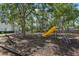 Community playground with mature trees, slide, climbing dome, wooden bench, and fencing at 7303 E Bank Dr, Tampa, FL 33617