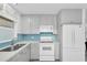 Bright kitchen with stainless steel sink, and white appliances at 8031 7Th N St, St Petersburg, FL 33702