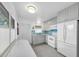 Well-lit kitchen featuring gray cabinets, white appliances, and blue tile backsplash at 8031 7Th N St, St Petersburg, FL 33702