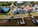 Aerial view of waterfront home, with a screened-in pool, dock, and lush landscaping and multiple boat docks at 828 Bayshore Dr, Tarpon Springs, FL 34689