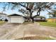Traditional-style home with mature trees, a 2-car garage, and a curved walkway leading to the front door at 828 Bayshore Dr, Tarpon Springs, FL 34689
