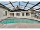Sparkling in-ground screened-in pool with a spacious patio and lake views, perfect for outdoor relaxation at 828 Bayshore Dr, Tarpon Springs, FL 34689