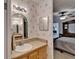 Bathroom featuring a vanity with a mirror, updated lighting fixtures, and an open view of bedroom at 8528 Fantasia Park Way, Riverview, FL 33578