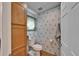 Cozy bathroom features a toilet, built-in cabinet, and patterned wallpaper at 8528 Fantasia Park Way, Riverview, FL 33578