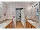 Bathroom with double vanities, mirrors, and a door leading to a separate toilet area at 8528 Fantasia Park Way, Riverview, FL 33578