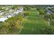 An aerial view of houses and golf course featuring lush greenery and sunny skies at 8975 Southern Charm Cir, Brooksville, FL 34613