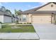Charming single-story home with a two-car garage and manicured lawn and an accent tree at 8975 Southern Charm Cir, Brooksville, FL 34613