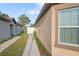 A view of the side of the home showing the walkway to the backyard and side of the house at 8975 Southern Charm Cir, Brooksville, FL 34613
