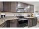 Well-equipped kitchen features stainless steel appliances, granite countertops, and sleek dark brown cabinets at 8975 Southern Charm Cir, Brooksville, FL 34613
