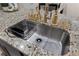 Granite kitchen island with stainless steel sink and stylish gold fixtures at 8975 Southern Charm Cir, Brooksville, FL 34613