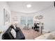 Cozy living room with a comfortable black couch, a glass coffee table, and a home office at 8975 Southern Charm Cir, Brooksville, FL 34613