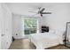 Bright bedroom with a white comforter, a window with sheer curtains, hardwood floors, and ceiling fan at 9481 Highland Oak Dr # 514, Tampa, FL 33647