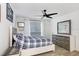 Bedroom with a ceiling fan, a window with sheer curtains, a decorative mirror and a chest of drawers at 9481 Highland Oak Dr # 514, Tampa, FL 33647