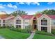 Inviting exterior of a condominium complex with manicured lawn, red roof, and a charming architectural style at 9481 Highland Oak Dr # 514, Tampa, FL 33647