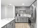 Bright kitchen featuring gray cabinetry, stainless steel appliances, marble countertops, and hardwood floors at 9481 Highland Oak Dr # 514, Tampa, FL 33647