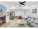 Open-concept living area with a modern kitchen, a gray sofa, light wood floors, and a ceiling fan at 9481 Highland Oak Dr # 514, Tampa, FL 33647