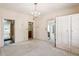 Spacious bedroom with a decorative chandelier, multiple doors and a large wardrobe at 101 Pampas Ave, Tarpon Springs, FL 34689