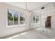 Bright dining room featuring mirrored walls, a chandelier, natural light, and a view of the kitchen at 101 Pampas Ave, Tarpon Springs, FL 34689