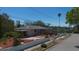 Home exterior features beautiful landscaping, driveway, and partial water view at 101 Pampas Ave, Tarpon Springs, FL 34689