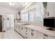Kitchen features white cabinets, a stainless sink, tiled flooring, and a view into another room at 101 Pampas Ave, Tarpon Springs, FL 34689