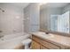 Bathroom with white tiled walls, a tub, and a single sink vanity at 10103 Courtney Oaks Cir # 103, Tampa, FL 33619