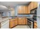 A functional kitchen showcasing wooden cabinetry, stainless steel appliances, and a breakfast bar at 10103 Courtney Oaks Cir # 103, Tampa, FL 33619