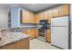 A cozy kitchen featuring wooden cabinets, tile floors, and modern appliances at 10103 Courtney Oaks Cir # 103, Tampa, FL 33619
