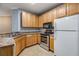 Well-lit kitchen features wooden cabinets, stainless steel appliances, and tiled floor at 10103 Courtney Oaks Cir # 103, Tampa, FL 33619
